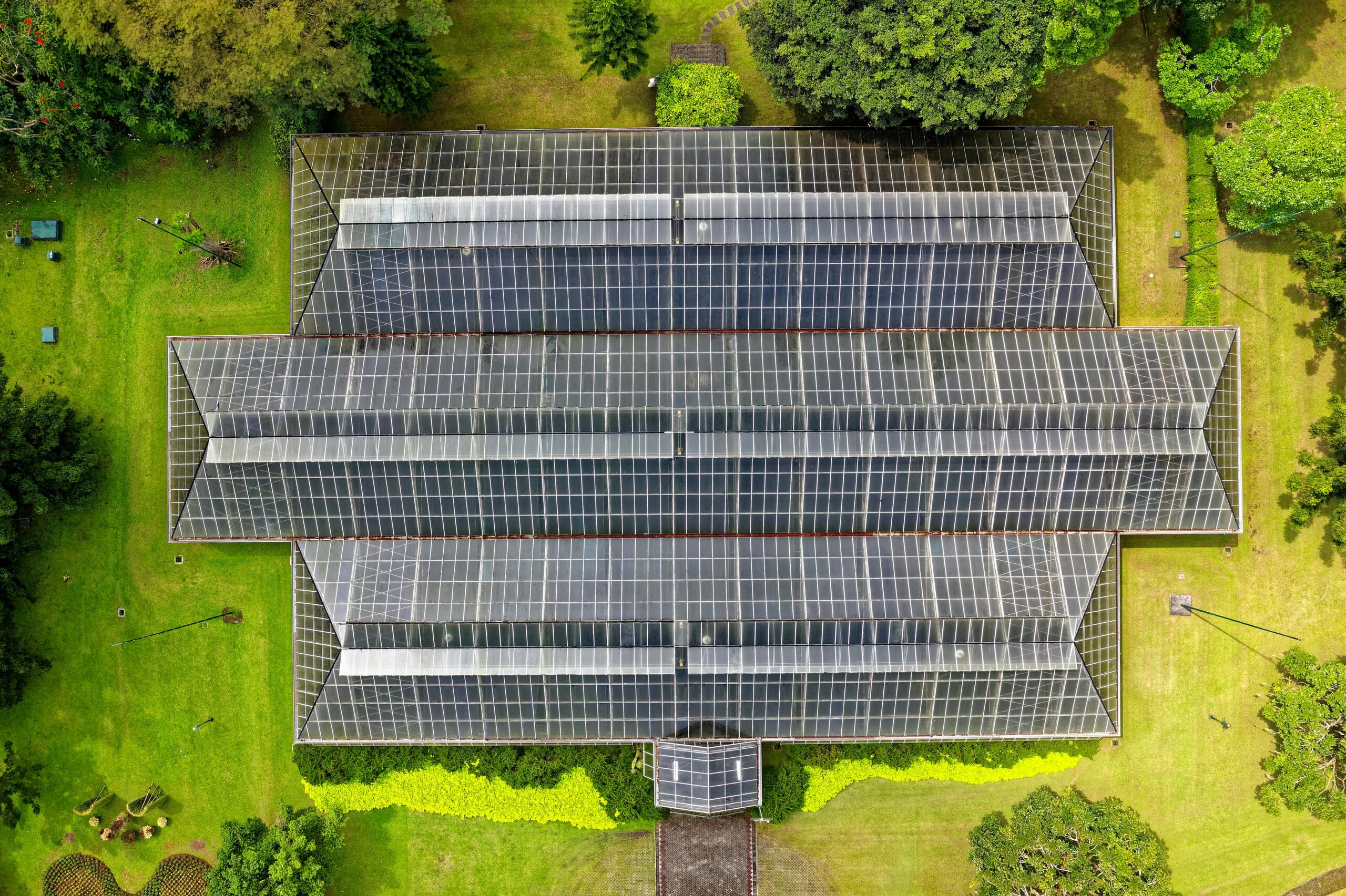 Top-down view of a modern greenhouse surrounded by lush greenery in Indonesia.
