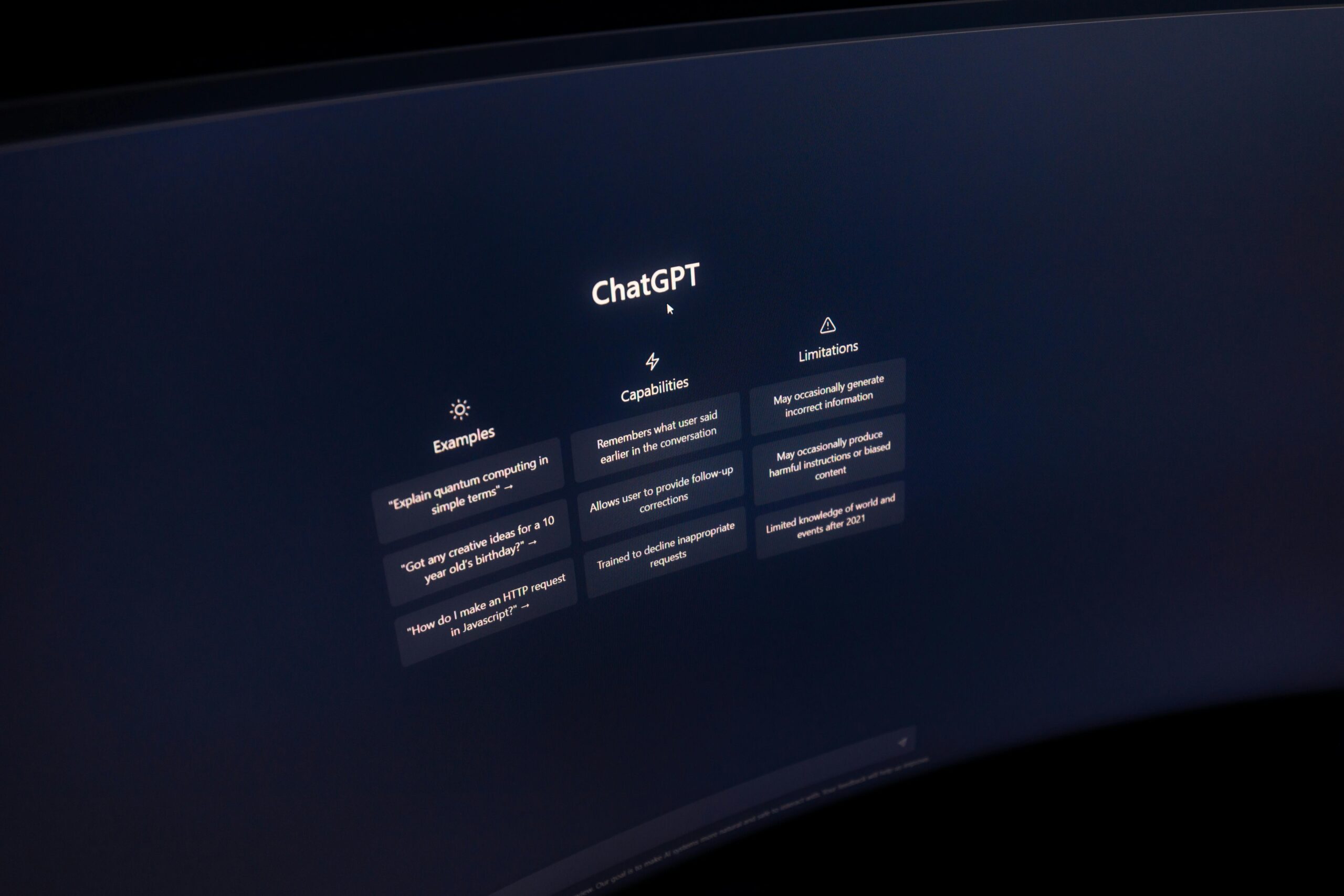 Close-up of a computer screen displaying ChatGPT interface in a dark setting.